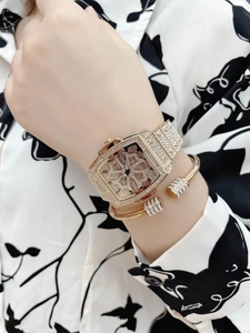 Gros plan sur la montre tonneau de luxe or rose et bracelet en cristal assorti au poignet