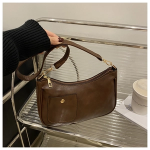 Detail of vintage dark brown faux leather shoulder bag with golden snap button and hardware