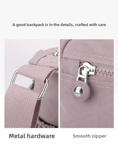 Detail view of purple nylon crossbody bag with silver D-ring and brand zipper puller