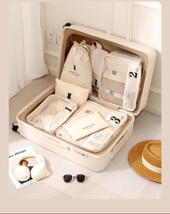 Detail view of numbered cream travel organizers with mesh panels inside a suitcase