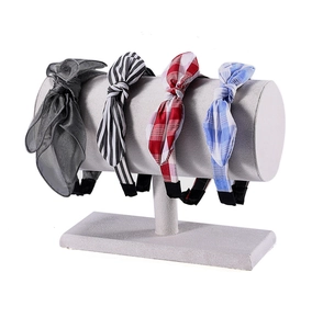 Detail of assorted bow headbands on a gray cylindrical display stand with various patterns