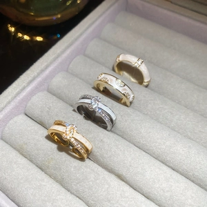 Detailed view of four 18k gold plated double layer rings with cubic zirconia and white enamel