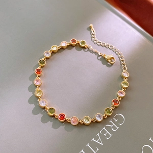 Détail d'un bracelet plaqué or avec des pierres de zircone multicolores et un fermoir