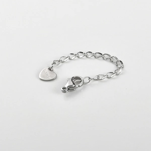 Macro view of silver stainless steel extension chain with lobster clasp and heart tag