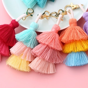 Colorful 3-tier cotton thread tassel keychains with golden lobster clasps on a white tray