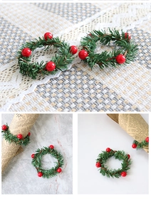 Detailed view of Christmas napkin rings with green pine needles and red festive berries