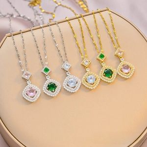 Detail of luxury gold and silver pendant necklaces featuring emerald and pink square zircons