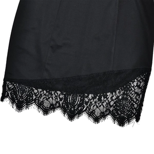 Detail of the black lace trim and high-quality fabric texture on the dress hem