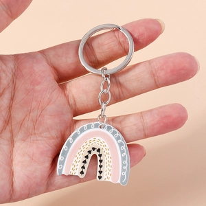 Detailed close-up of acrylic rainbow keychain in soft pink and grey with heart pattern