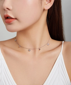 Close-up detail of silver shell pendant necklace on model showcasing elegant jewelry style