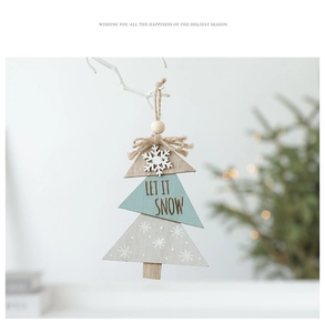 Detail of wooden Christmas tree ornament with Let It Snow text on rustic white branch