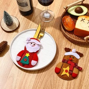 Christmas Santa and reindeer cutlery holders on a wooden table with festive decor