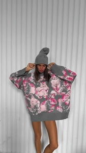 Close-up of a grey oversized knit sweater featuring pink and white rabbit patterns