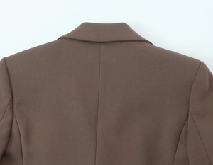 Détail du col d'un blazer marron à boutonnage croisé avec épaulettes et texture de tissu