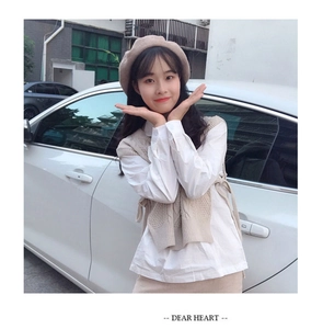 Outdoor street style view of beige wool beret with matching knitted sweater vest