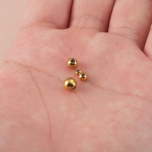 Gold stainless steel spacer beads in hand for size comparison and jewelry DIY making
