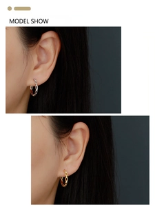 Model wearing gold and silver chain link hoop earrings with micro-set sparkling crystals