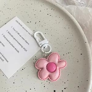 Close-up of pink leather flower keychain with fine stitching and white plastic hook