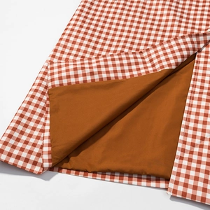Détail du tissu à carreaux orange montrant la texture coton et la doublure brune