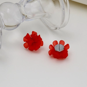Elegant red matte flower stud earrings with 925 silver needles on a clear glass prop