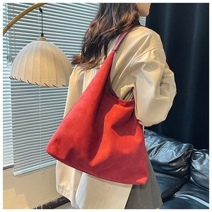 Model wearing a large red faux suede tote bag for casual commuting over the shoulder