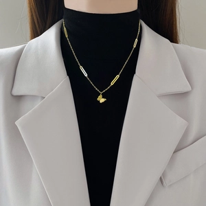 Minimalist gold-plated titanium steel butterfly necklace worn by a model over a black top