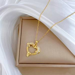 Elegant gold titanium heart necklace with dolphin pendant and crystals on jewelry box