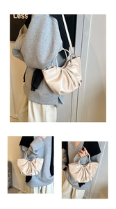 Detail shot of beige ruched cloud bag showing the soft pleats and versatile carrying style