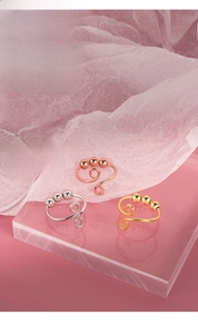 Detailed close-up of three anxiety relief rings in gold, silver and rose gold finishes