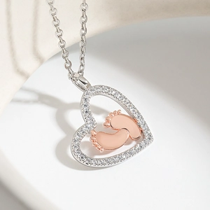 Heart pendant necklace with rose gold baby footprints and white cubic zirconia accents