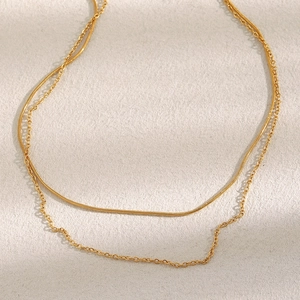 Detail of double-layered 18K gold-plated necklace featuring sleek snake and O-link chains