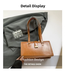 Detail of brown faux leather tote bag with lychee texture and gold metal hardware