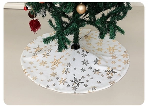 Detail of white Christmas tree skirt featuring golden and grey snowflake patterns