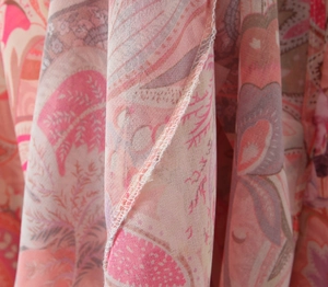Macro shot of pink paisley floral print fabric and seam details on backless maxi dress