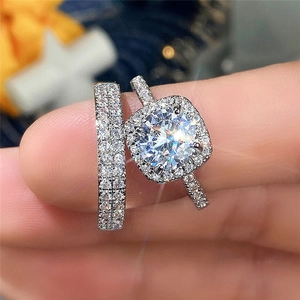 Macro view of a silver ring set featuring a halo solitaire and a pave wedding band