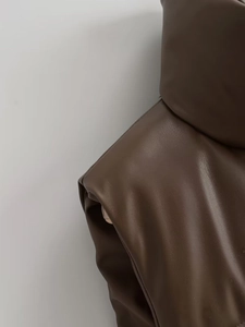 Detail of dark brown faux leather vest showing premium pebbled texture and shoulder seam