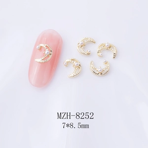 Detail of crescent moon nail art charms with white pearls and gold hammered metal finish