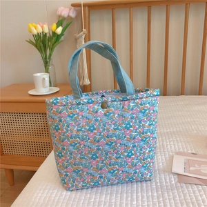 Close-up of floral lunch bag with quilted texture and vintage bronze metal snap button