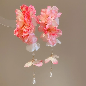 Détail de pinces à cheveux fleur en mousseline rose avec longs glands et perles