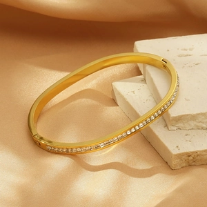 Macro d'un bracelet en titane doré serti de diamants carrés sur pierre et soie