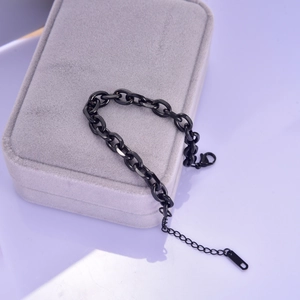Detail of a minimalist black chunky chain bracelet with lobster clasp on a jewelry box