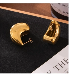 Detail of gold double-layer teardrop earrings with a mirror-polished metallic finish