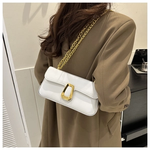 Detail of white patent leather shoulder bag with gold geometric buckle and chain strap