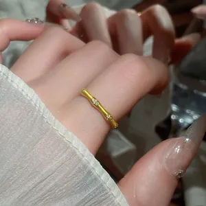 Elegant gold bamboo joint open bangle with zircon inlay shown on woman's wrist
