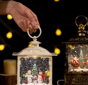 Close-up of a white vintage Christmas lantern with snowman family and glowing lights