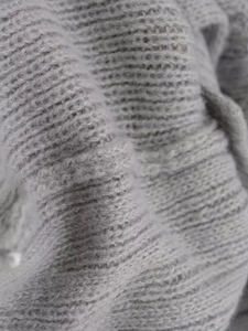 Macro view of grey knit fabric texture showing soft wool blend fibers and detailed weave