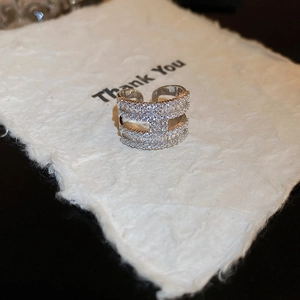 Macrodetail van de zilveren ring met dubbele rij zirkonen en H-vormige geometrische brug