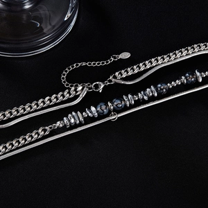 Detail of silver double-layer stainless steel bracelet with hematite beads and S.Steel tag