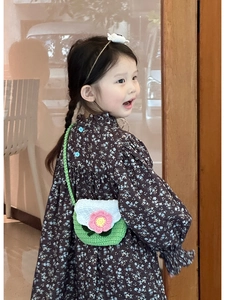 Kids hand-knitted bright green flower crossbody bag shown on a young girl model