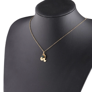 Golden Leo constellation necklace with green birthstone shown on a black mannequin bust